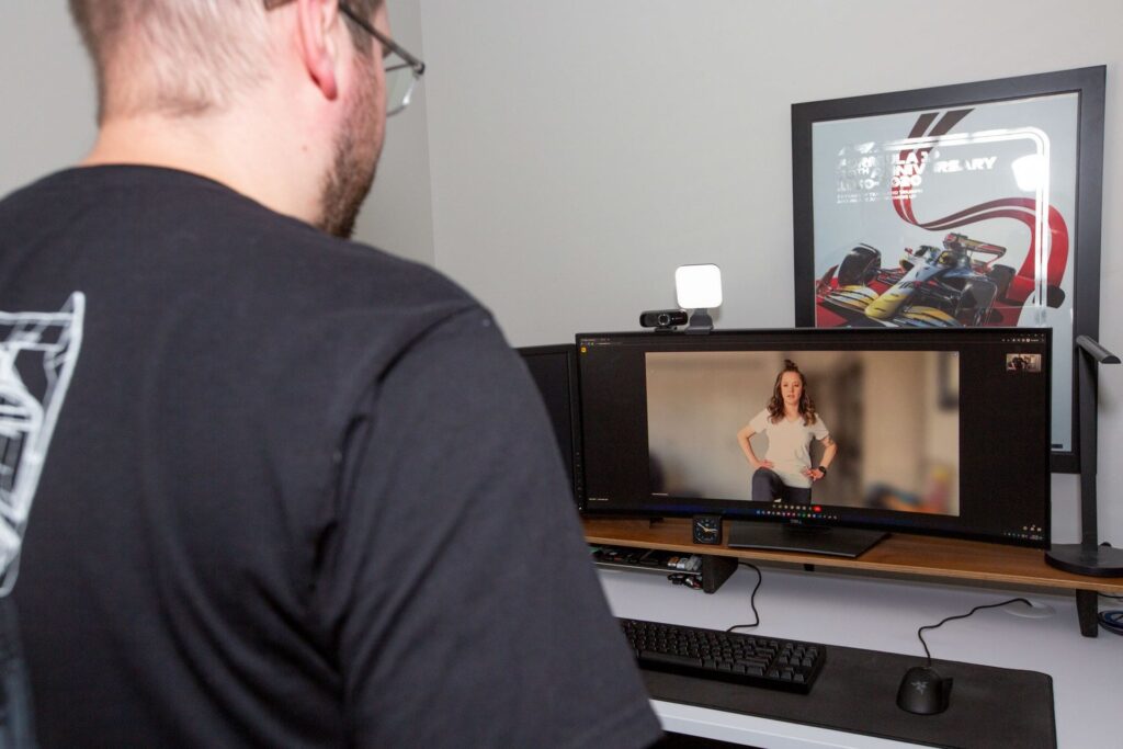 A person watching how to do exercises during a remote coaching lesson on a video call.